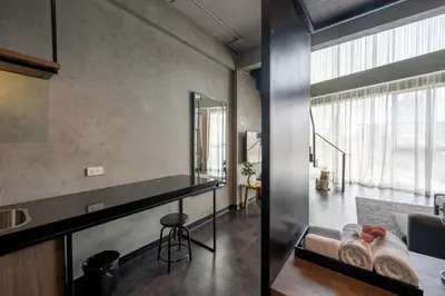 a living room with a table and a mirror at The Ex Capital Hotel Bangkok by Dancenter in Bangkok