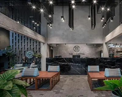 a lobby with tables and chairs in a building at The Ex Capital Hotel Bangkok by Dancenter in Bangkok
