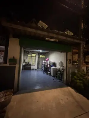 an empty garage at night with the door open at Homestay in Tha Akatsayan Don Muang
