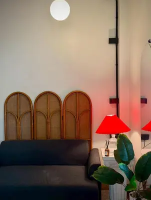 a living room with a couch and a red lamp at MornSamyan in Bang Rak