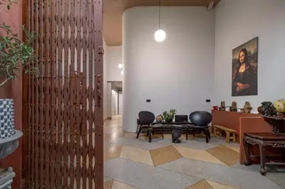 a lobby with a wooden partition with chairs and a table at MornSamyan in Bang Rak