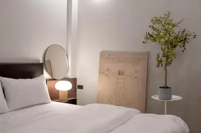 a bedroom with a bed and a painting of a man at MornSamyan in Bang Rak