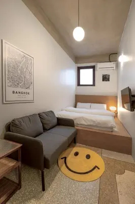 a small bedroom with a bed and a couch at MornSamyan in Bang Rak