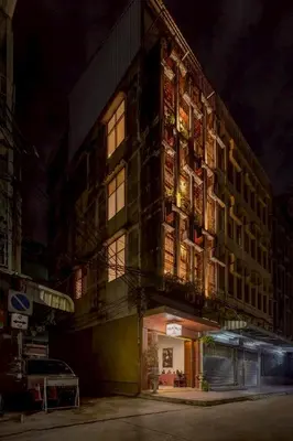 a tall building with lights on it at night at MornSamyan in Bang Rak