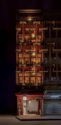 a tall building with lights on it at night at MornSamyan in Bang Rak
