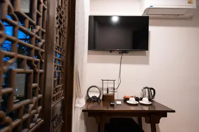 a room with a table with a television on a wall at Soultel โซลเทล in Khlong San