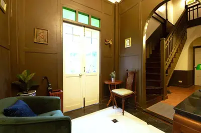 a living room with a door and a stair case at Casa Acero in Bangkok