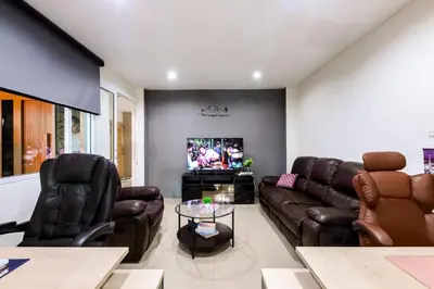 a living room with leather furniture and a flat screen tv at Sheikh Stay In Hostel in Bangkok