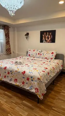 a bedroom with a bed with a comforter on it at Rewadee House in Nonthaburi