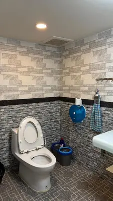 a bathroom with a toilet and a sink at Rewadee House in Nonthaburi