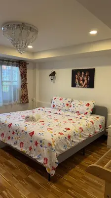 a bedroom with a bed with a comforter on it at Rewadee House in Nonthaburi