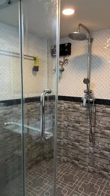 a shower with a glass door in a bathroom at Rewadee House in Nonthaburi