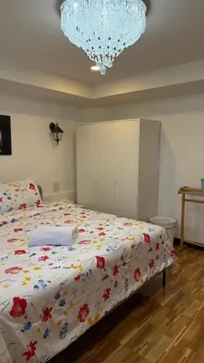 a bedroom with a large bed with a floral comforter at Rewadee House in Nonthaburi