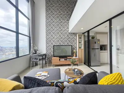 a living room with a couch and a tv at Near BTS l Modern Luxury l By Sontana in Bangkok