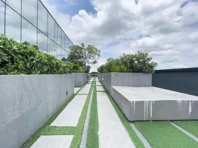 a concrete wall with a bench in front of a building at Near BTS l Modern Luxury l By Sontana in Bangkok