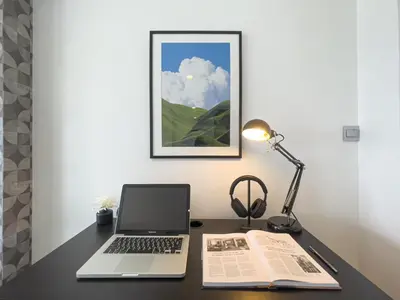 a desk with a laptop and a book and a lamp at Near BTS l Modern Luxury l By Sontana in Bangkok