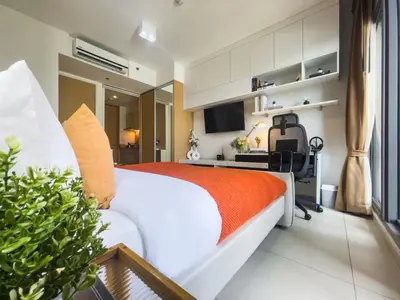 a bedroom with a bed and a desk with a computer at Walk to BTS Ekkamai l Urban Sukhumvit Living l Fast WiFi in Bangkok