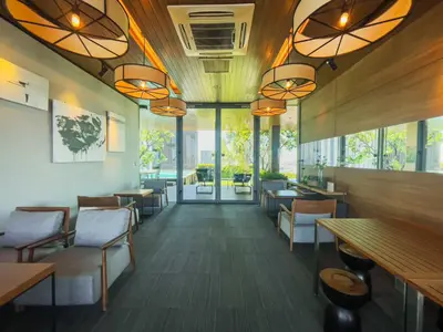 a restaurant with tables and chairs and windows at Walk to BTS Ekkamai l Urban Sukhumvit Living l Fast WiFi in Bangkok