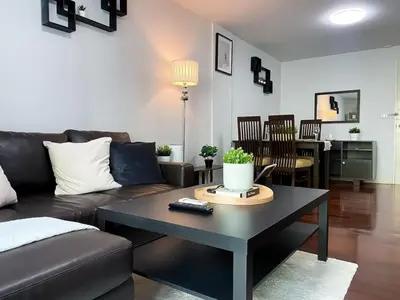 a living room with a couch and a table at Spacious 53 Sqm l BTS Thong Lo l Ultra Fast WiFi in Bangkok