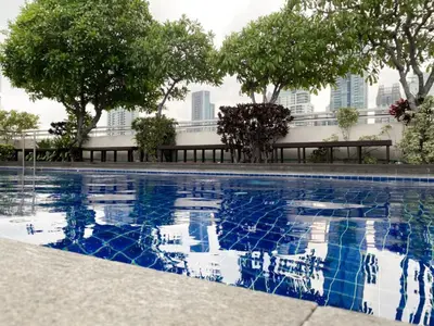 a swimming pool with trees and buildings in the background at Spacious 53 Sqm l BTS Thong Lo l Ultra Fast WiFi in Bangkok
