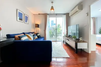 a living room with a blue couch and a tv at Contemporary 53 SQM - BTS Thong Lo - Ultra Fast WiFi in Bangkok