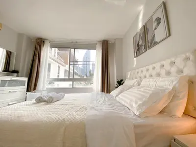 a white bedroom with a large bed and a window at Contemporary 53 SQM - BTS Thong Lo - Ultra Fast WiFi in Bangkok