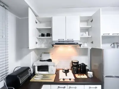 a kitchen with white cabinets and a counter with a microwave at Contemporary 53 SQM - BTS Thong Lo - Ultra Fast WiFi in Bangkok