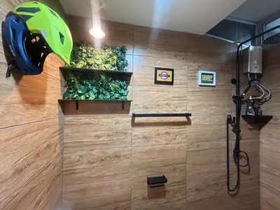 a bathroom with a shower with a helmet on the wall at Secret Retro Vintage Building ห้องลับเรโทรในตึกวินเทจ in Ban Song Hong