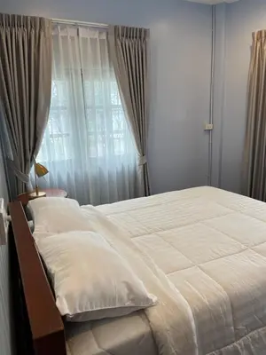 a bedroom with a large bed and a window at Saen Saran property in Sathani Bang Ramat