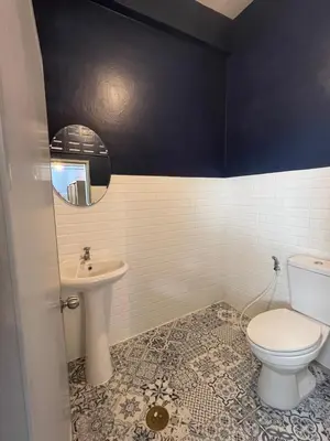a bathroom with a toilet and a sink at Saen Saran property in Sathani Bang Ramat