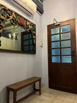 a mirror and a bench next to a door at Saen Saran property in Sathani Bang Ramat