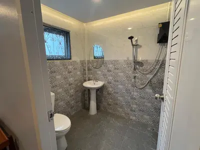 a bathroom with a toilet and a sink at Saen Saran property in Sathani Bang Ramat