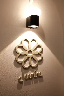 a light with a flower on a wall at The Shantipan Jasmine - Cozy City Retreat 400m from BTS Station in Bangkok