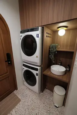 a washing machine and a microwave in a bathroom at The Shantipan Jasmine - Cozy City Retreat 400m from BTS Station in Bangkok