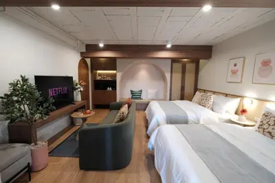 a hotel room with two beds and a tv at The Shantipan Mandala - Cozy City Retreat 400m from BTS Station in Bangkok