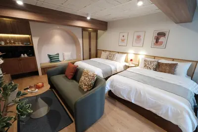 a hotel room with two beds and a couch at The Shantipan Mandala - Cozy City Retreat 400m from BTS Station in Bangkok