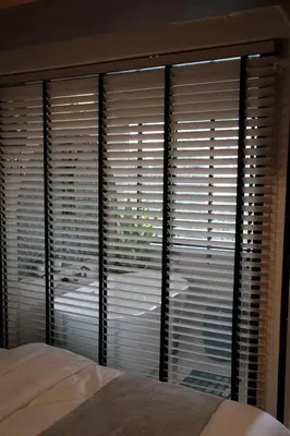 a bedroom with a large window with blinds at The Shantipan Mandala - Cozy City Retreat 400m from BTS Station in Bangkok