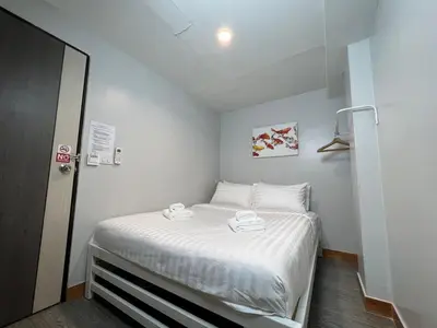 a small bedroom with a bed with two towels on it at Pratunam Family House 2 in Bangkok