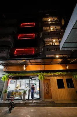 a woman is standing outside of a restaurant at Pratunam Family House 2 in Bangkok