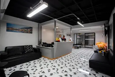 a lobby with a counter and a person in a room at Pratunam Family House 2 in Bangkok