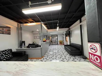 a lobby with a waiting room with couches and a counter at Pratunam Family House 2 in Bangkok