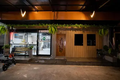 a front door of a restaurant with a motorcycle parked outside at Pratunam Family House 2 in Bangkok