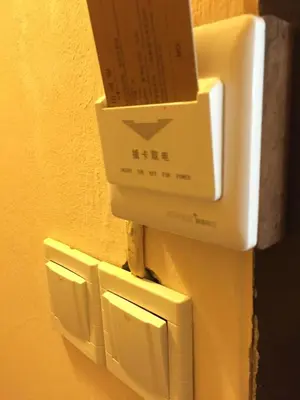 a box is hanging on a wall with three outlets at Eco House in Bangkok