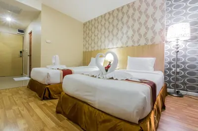 a hotel room with three beds and a bathroom at Three Seasons Bangkok in Bangkok