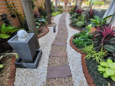 a garden with a stone path with a vase in the middle at Three Seasons Bangkok in Bangkok