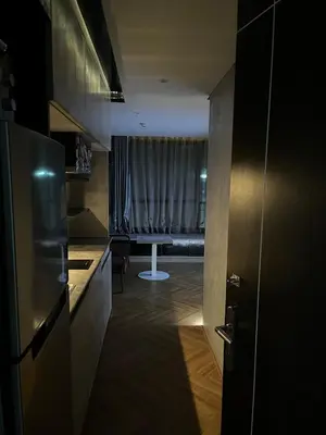 a kitchen with a window with a couch in the background at Spaceous Appartment on Sukhumvit in Bangkok