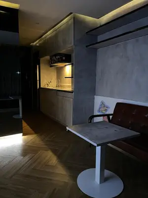 a kitchen with a table and a bench in a room at Spaceous Appartment on Sukhumvit in Bangkok