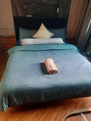 a bed with a blue comforter with a towel on it at Spaceous Appartment on Sukhumvit in Bangkok