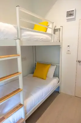 a room with bunk beds with a yellow pillow at Kanal Bangkok Service Residence in Ban Khlong Bang Chak
