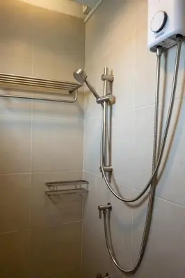 a shower in a bathroom with a shower head at Kanal Bangkok Service Residence in Ban Khlong Bang Chak